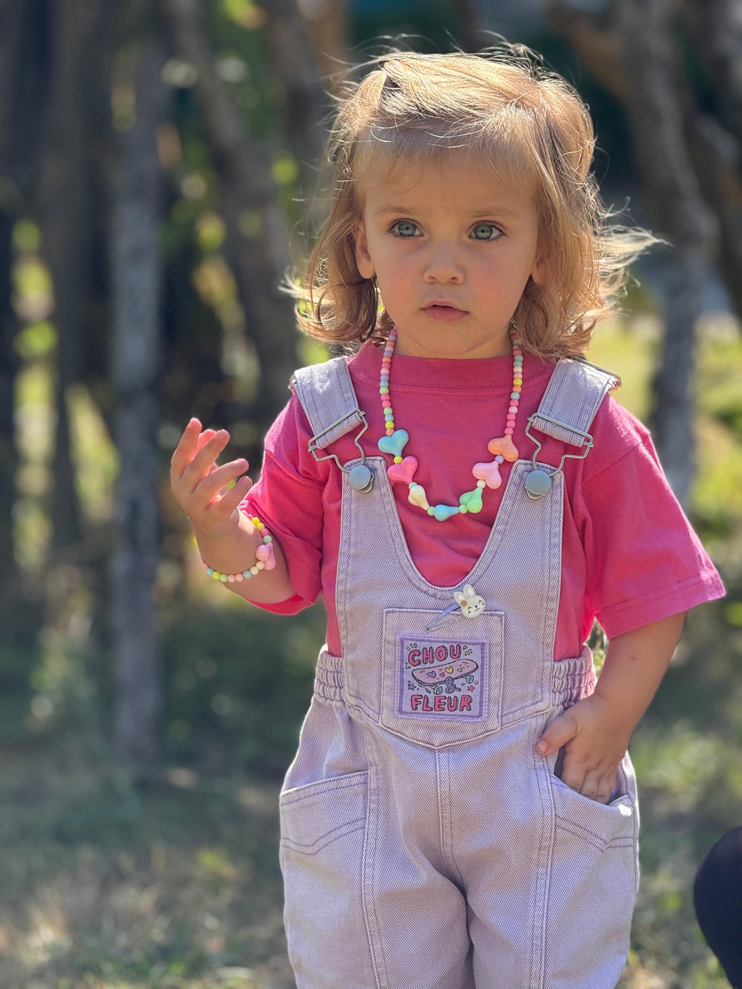 Fille 3 ans en salopette mauve une main dans la poche