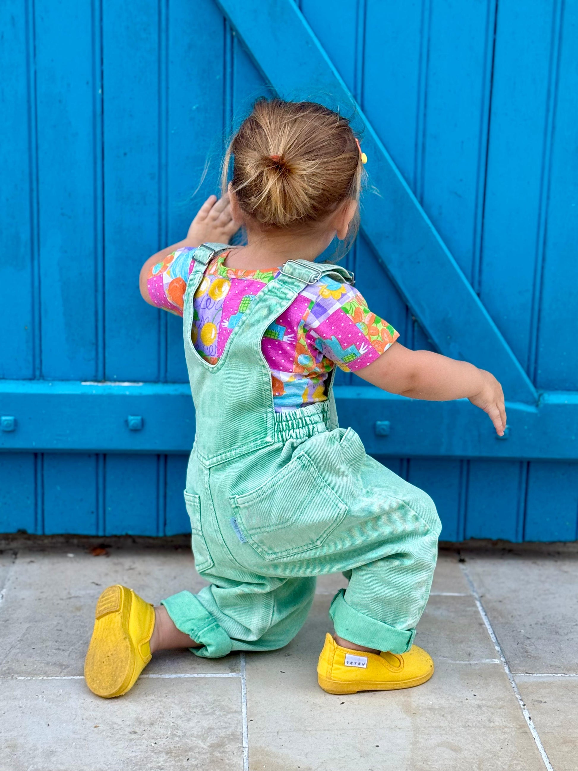 Fille 2 ans en salopette verte vintage de dos