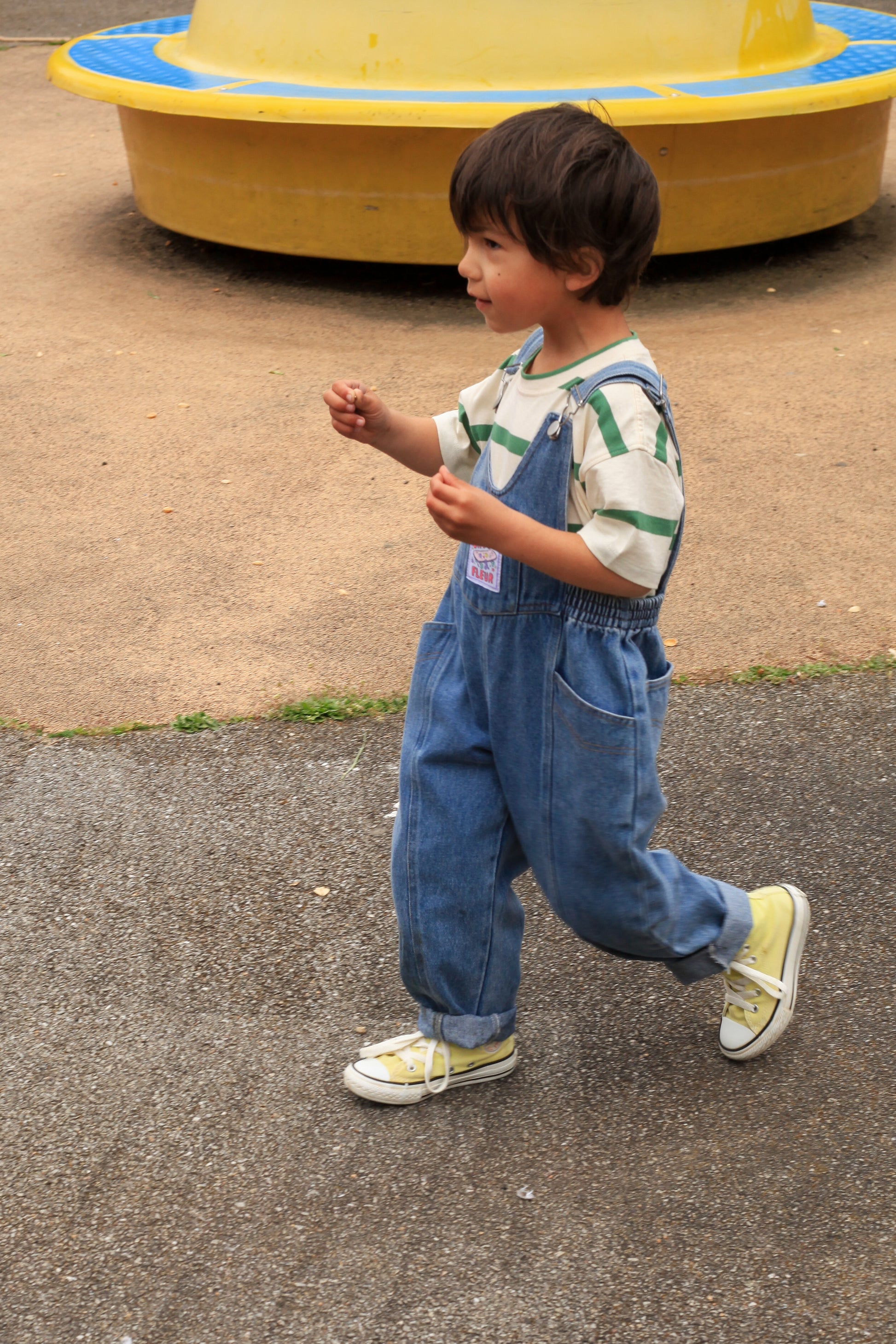Profil d’un enfant en salopette Billie Jean, t-shirt rayé — mode enfant néo-vintage.