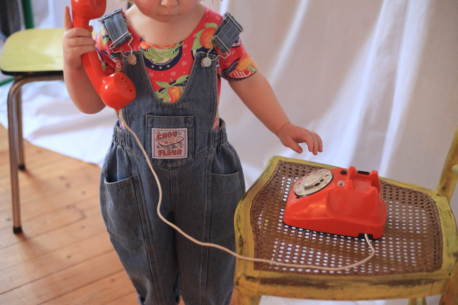 Salopette enfant en jean bleu avec étiquette tissée sur la bavette, tenue tendance et confortable.