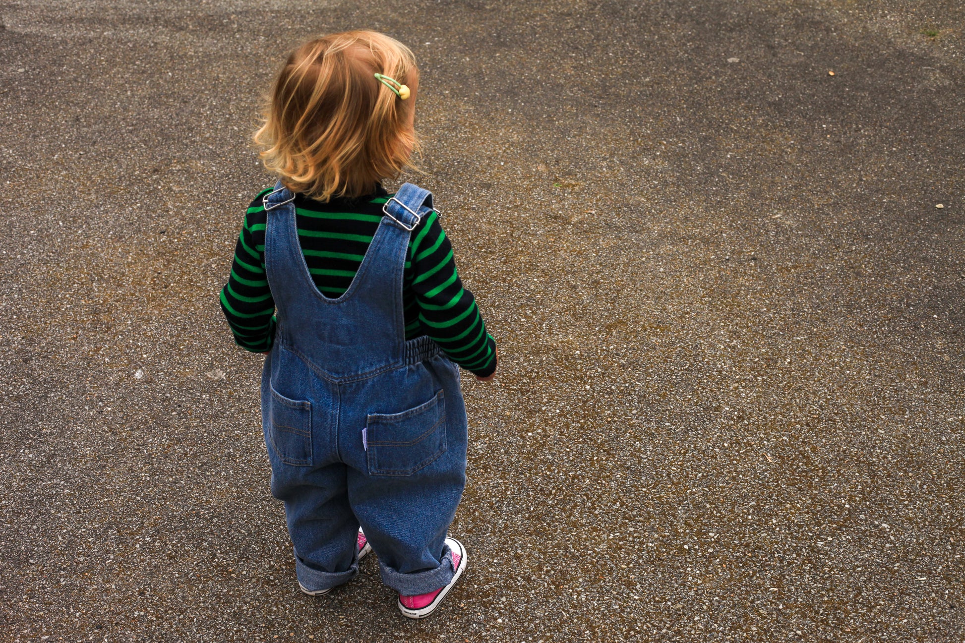 Salopette en jean pour enfant, vue de dos en extérieur, look urbain décontracté avec baskets