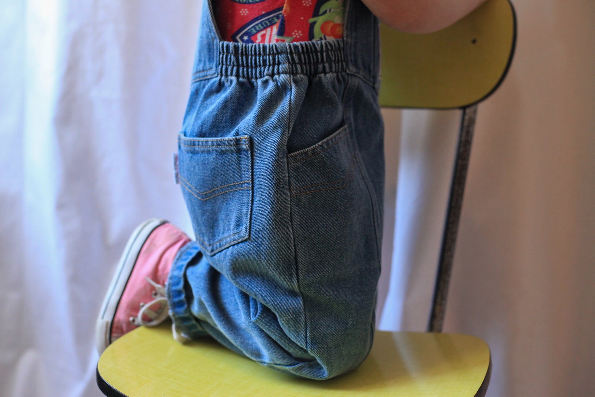 Gros plan couture sur coté salopette denim bleu enfant