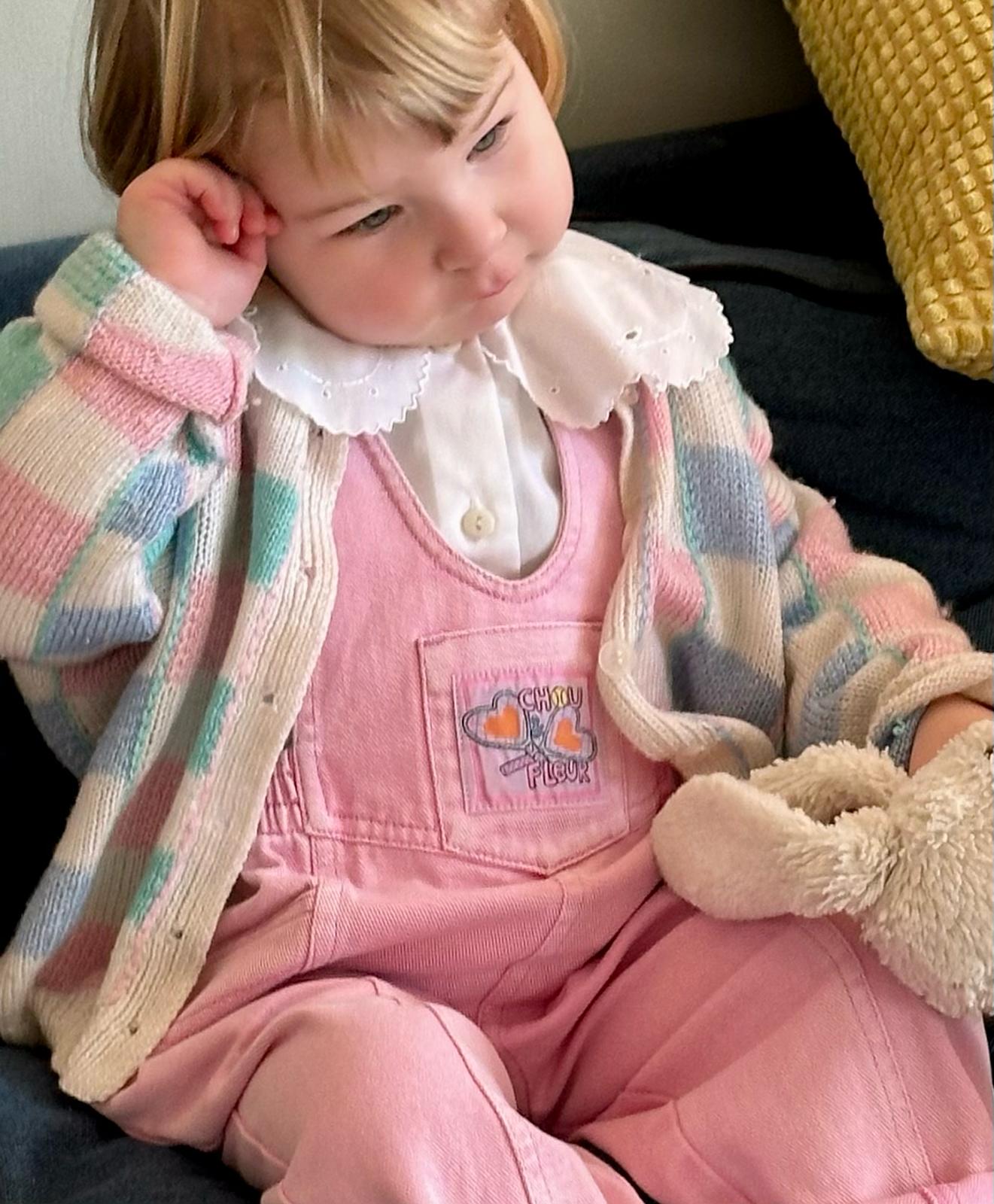 Fille 3 ans en salopette rose vintage et chemisier col claudine, assise